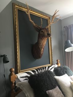 a deer head mounted on the wall above a bed