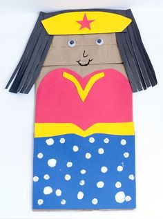 a paper doll made to look like a girl with long hair, wearing a hat and holding a heart