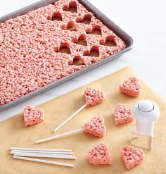 the ingredients for making heart shaped rice krispy kreme treats are displayed on a baking sheet