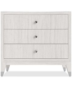 a white dresser with three drawers and two knobs on the top, in front of a