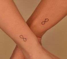 two people with matching tattoos on their legs, one is holding the other's hand