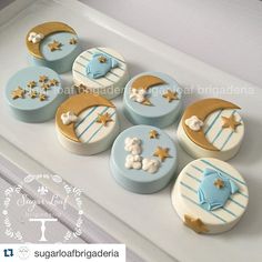 six decorated cupcakes in the shape of moon and stars on a white tray