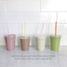 three different colored smoothies with straws in them