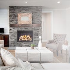 a living room filled with furniture and a fire place in the middle of the room