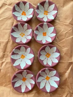 six pink bowls with white flowers painted on them