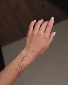 a woman's hand with a small tattoo on her left wrist and the other arm