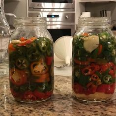 two glass jars filled with food sitting on top of a counter