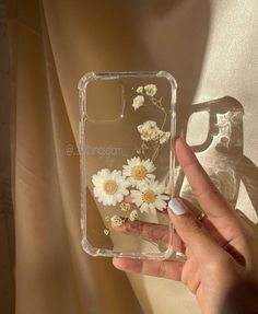 a hand holding a clear case with flowers on it