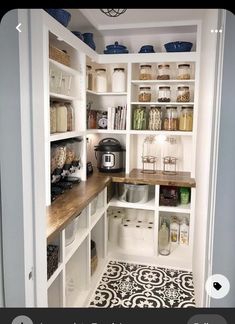 an organized pantry with white shelving and wooden shelves