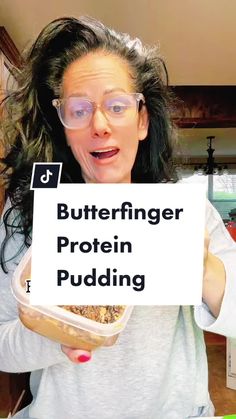 a woman holding up a sign that says butterfingerer protein pudding in front of her face