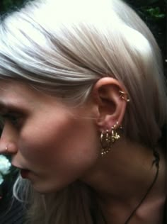 a woman with blonde hair wearing gold earrings