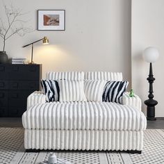 a white couch sitting on top of a floor next to a lamp