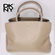 Brand: Dkny Size: Medium Type: Paige Leather Satchel Material: Leather And Polyester Color: Dark Tan / Taupe / Light Khaki In Excellent Condition!! **Will Consider All Offers** From Dkny Website: Product Details: Genuine Leather Imported Zipper Closure Gold-Tone Hardware Textured Leather Triple Entry Satchel, Dual Rolled Handles, Optional Shoulder Strap 1 Slip Pocket, 1 Zipper Pocket Dual Rolled Handles, Optional Strap 5" Handle, 21" Strap 11.5"W X 8.5"H X 5.25"D 30.16 Oz Leather; Lining: Polyester Will Consider All Reasonable Offers *Color Shades May Show Differently On Different Devices. Dkny Paige Satchel, Dkny Bags, Dark Tan, Color Shades, Leather Satchel, Zipper Pocket, Satchel, Crossbody Bag, Shoulder Strap