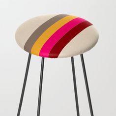 a multicolored stool with black legs and an upholstered seat on the back