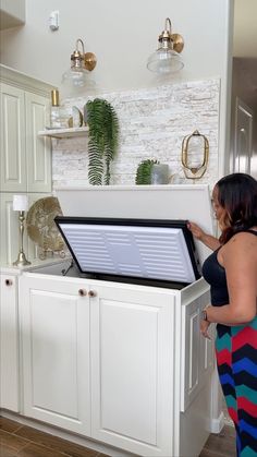 a woman standing in front of a white cabinet