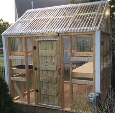 a small wooden building with a chicken coop in the back ground and windows on each side