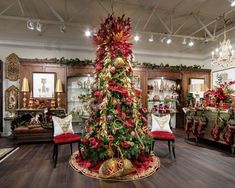 a decorated christmas tree in the middle of a room with red and gold decorations on it