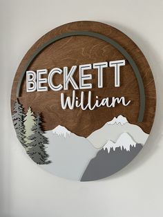 a wooden sign with the words beckett william on it and mountains in the background