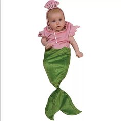 a baby in a pink shirt and green mermaid tail