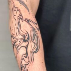 a man's arm with black and white ink on it, showing the design