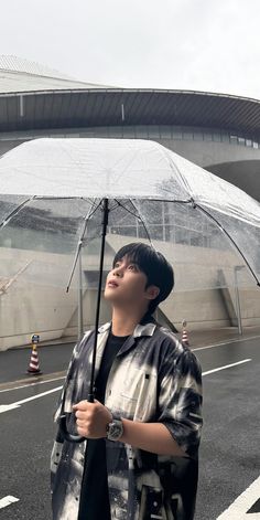 a young man holding an umbrella on the street