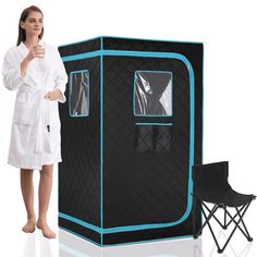 a woman in a bathrobe standing next to a black and blue portable shower