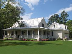 a large white house sitting on top of a lush green field