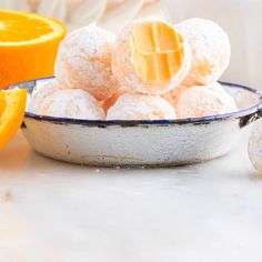 oranges and powdered sugar balls in a bowl