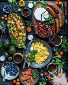 a table full of food and drinks on it's sides, including fruit, salads, sandwiches