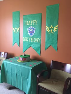 a table with a cake on it in front of two banners that say happy birthday