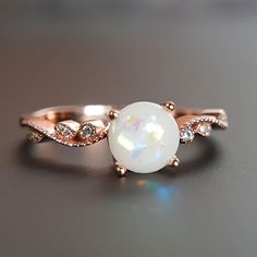 Beautiful handmade item! Here, on Etsy made as simulation only-just resin and white color.  Breastmilk Ring made with white gold plated sterling silver or plated with rose or yellow gold. Opal effect breastmik 7mm rounded shaped stone. Any size available. Rose gold,  or white gold plated options.  Pearl powder or opal effect can be added to this fine breastmilk ring. Beautiful inlaid cubic zirconia surround and accentuate your breastmilk stone while a skin-friendly 925 sterling silver ring core. Sterling Silver Rose Gold Crystal Ring, Rose Gold Sterling Silver Crystal Ring, White Opal Birthstone Crystal Ring, White Opal Crystal Ring For Gift, Rose Gold Ring With Round Stone For Gift, White Round Crystal Ring Gift, Rose Gold Opal Birthstone Ring For Gift, Rose Gold Opal Birthstone Ring As Gift, Rose Gold Ring Gift