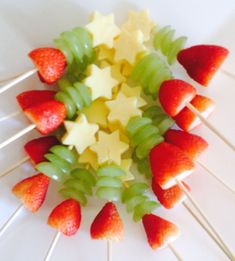 strawberries and kiwis are arranged on a skewer with white stars