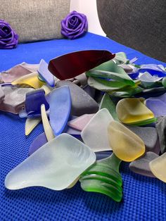 several pieces of glass sitting on top of a blue table cloth next to a gray chair