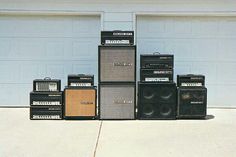 five amps are lined up in front of a garage door and one is empty