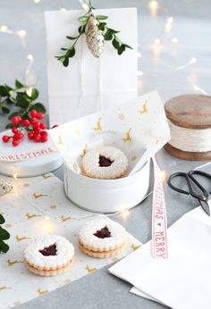 a table topped with cookies covered in frosting next to scissors and other items on top of a table