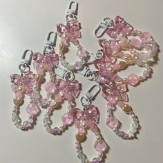 pink and white beaded charms with pearls on the ends are arranged in a cluster