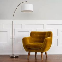 a yellow chair sitting on top of a hard wood floor next to a white wall