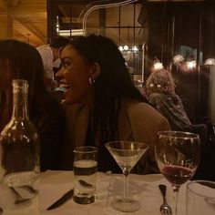 two women sitting at a table with wine glasses