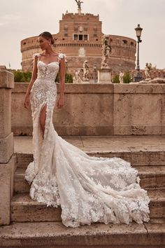 a woman in a wedding dress standing on some steps