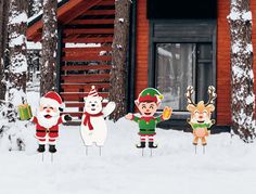 christmas yard decorations in front of a cabin