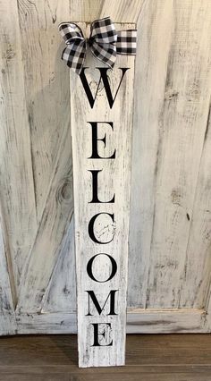 a wooden welcome sign with a bow on it