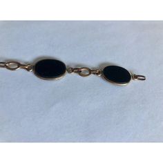 This is part of Chairish’s Fine Jewelry assortment.  This gorgeous 1950s 12K Gold Oval Onyx Link Bracelet has five smooth-sided black onyx stones wrapped in 12K gold and separately by matching chain links. Simply elegant and ready to wear, this link bracelet, which appears to have the Coro mark (illegible), will be a fabulous addition worn alone or stacked with other complementary bracelets for maximum impact.  Dimensions: 7.5" L Condition: Good vintage condition; wear consistent with age. Please see pics for details. Marks: 12KT, Coro(?) Elegant Black Link Jewelry, Classic Black Link Jewelry, Timeless Oval Black Enamel Jewelry, Black Link Jewelry For Formal Occasions, Vintage Oval Link Bracelet With Polished Finish, Vintage Gold Bracelet With Oval Link For Formal Occasions, Vintage Oval Link Gold Bracelet For Formal Occasions, Vintage 14k Gold Oval Link Bracelets, Vintage Onyx Gold Jewelry