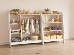 a white shelf with clothes and toys on it