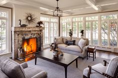 a living room filled with furniture and a fire place in the middle of a room