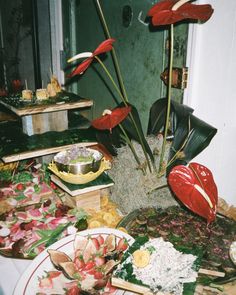 the table is covered with plates and flowers