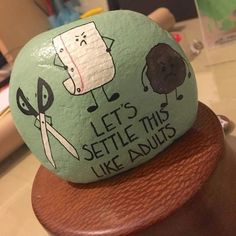 there is a rock that has been painted with scissors and other things on top of it