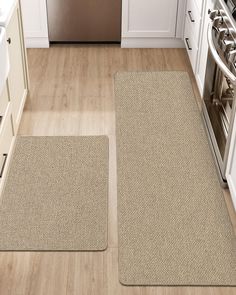 two rugs in the middle of a kitchen floor next to an oven and dishwasher