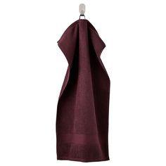 a maroon towel hanging on a hook with the bottom half folded up to show it's folds