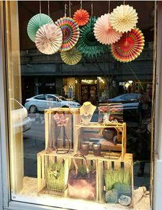 there is a display in the window with paper fans hanging from it's windowsill