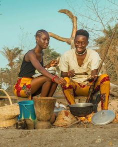 two women sitting next to each other near pots and pans